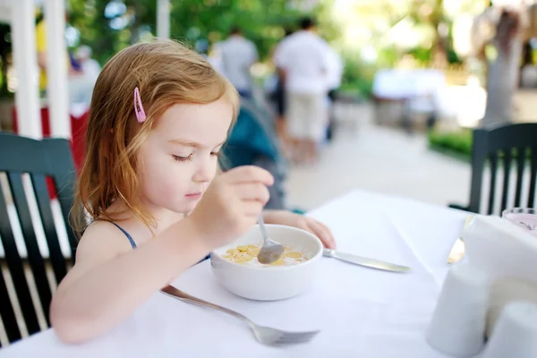 Söt liten flicka äter spannmål — Stockfoto