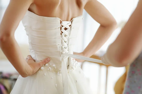 Ajudando a noiva a colocar seu vestido de noiva — Fotografia de Stock