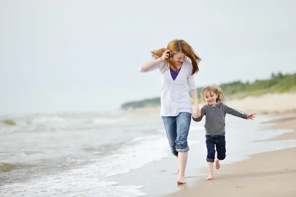 Kleines Mädchen und ihre Mutter am Strand — Stockfoto
