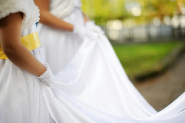 Little bridesmaids holding bride's dress — Stock Photo, Image