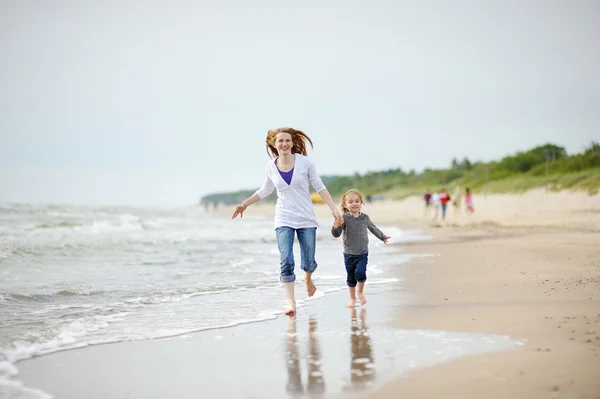 Dziewczynka i jej matka na plaży — Zdjęcie stockowe