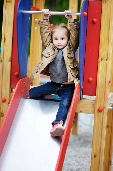 Entzückendes Mädchen, das Spaß auf einem Spielplatz hat — Stockfoto