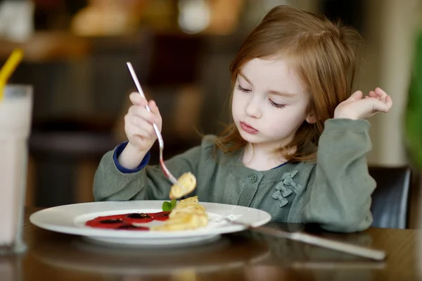 Söt liten flicka äter pannkakor — Stockfoto