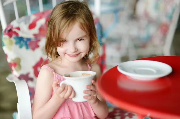 Красивая маленькая девочка пьет горячий шоколад — стоковое фото