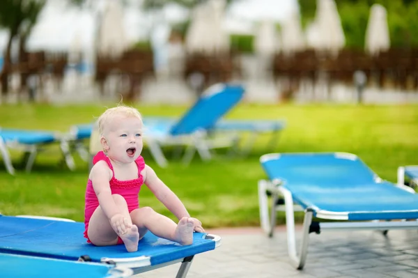 Bir şezlong üzerinde oturan sevimli bebek kız — Stok fotoğraf