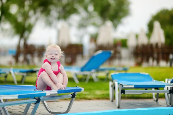 Adorable toddler girl sitting on a sunbed — Stock Photo, Image