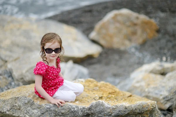 Adorabile bambina seduta su una roccia — Foto Stock