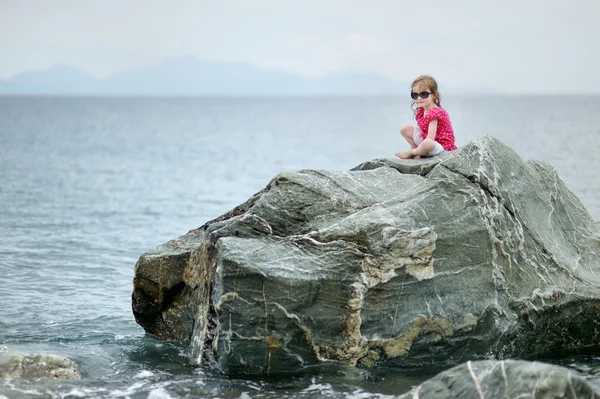Urocza dziewczynka siedzi na skale — Zdjęcie stockowe