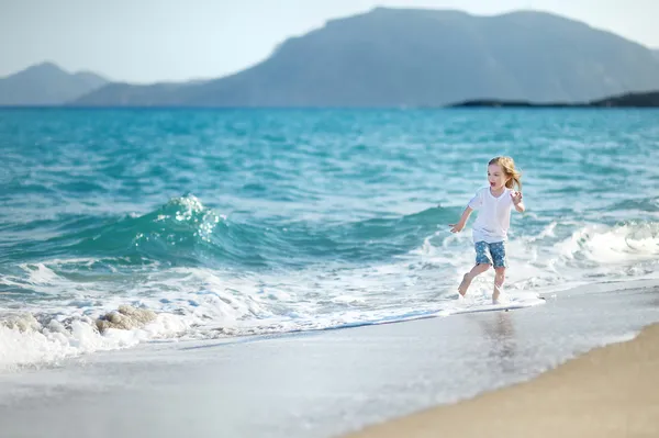 Suloinen pieni tyttö hiekkarannalla — kuvapankkivalokuva