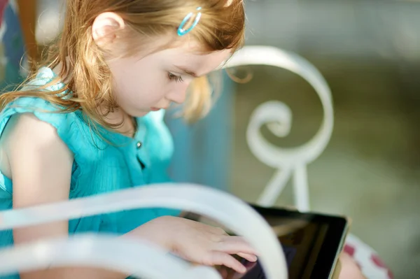 Маленькая девочка играет на цифровом планшете — стоковое фото