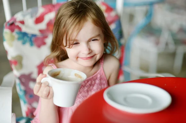 Entzückendes kleines Mädchen trinkt heiße Schokolade — Stockfoto