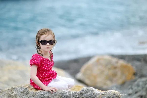 Adorabile bambina seduta su una roccia — Foto Stock