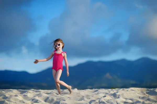 Bir kumsalda oynarken sevimli küçük kız — Stok fotoğraf