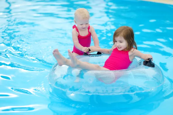 Hermanitas divirtiéndose en una piscina — Foto de Stock