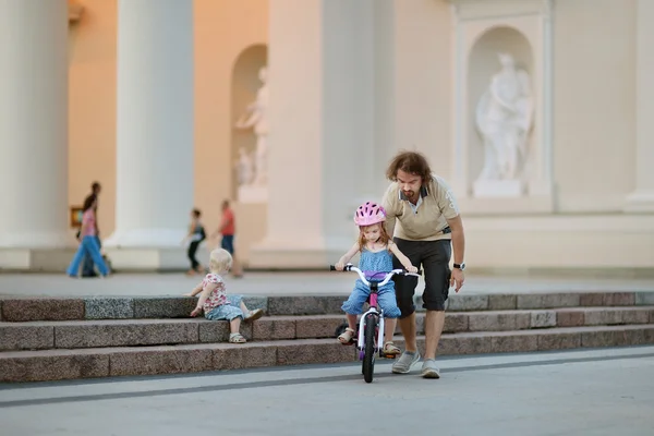 Jovem pai ensinando sua filha a andar de bicicleta — Fotografia de Stock