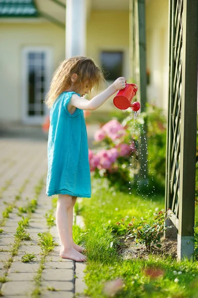 Sevimli küçük kız sulama çiçekler — Stok fotoğraf