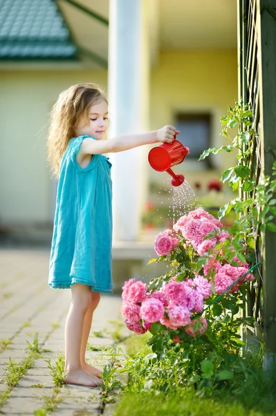 Bonito menina regando flores — Fotografia de Stock