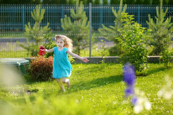Niedliches kleines Mädchen beim Blumengießen — Stockfoto