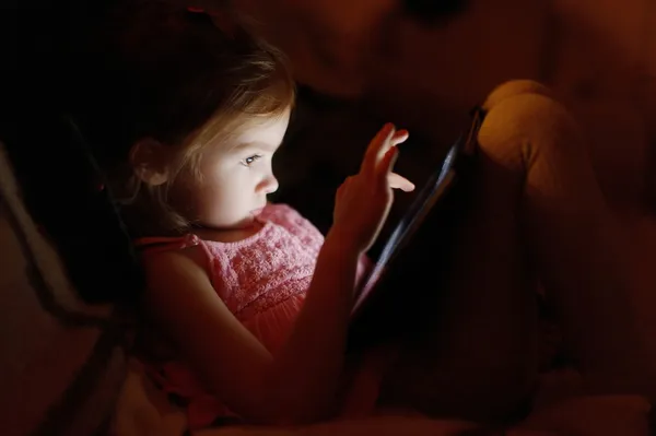 Чарівна маленька дівчинка грає на планшеті — стокове фото