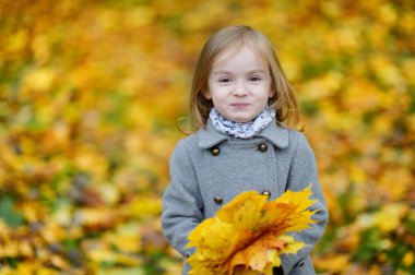 sevimli kız sonbahar gününde eğleniyor