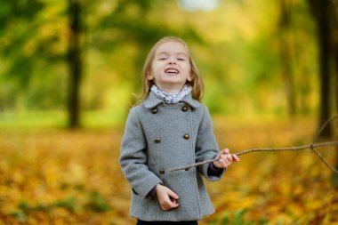 sevimli kız sonbahar gününde eğleniyor