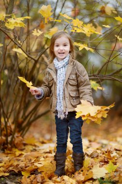 sevimli kız sonbahar gününde eğleniyor