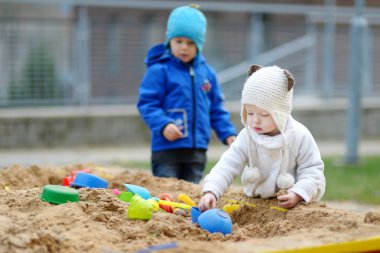 iki çocuk kum havuzunda oynamayı