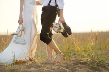 Gelin ve damat bir plaj gün batımında