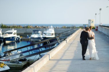Mutlu gelin ve damat iskelede yürüyüş