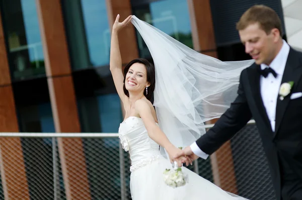 Happy bride and groom in a city — Stock Photo, Image