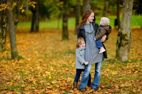 Ung mamma och hennes två små döttrar på hösten — Stockfoto