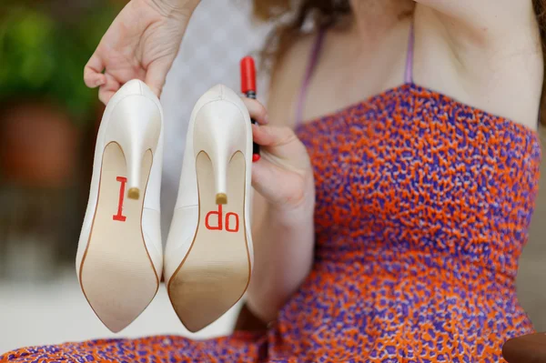 Demoiselle d'honneur montrant les chaussures de la mariée — Photo
