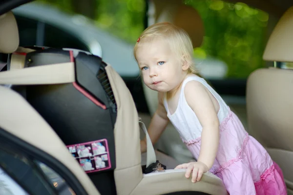 Menina da criança entrando em um assento de carro — Fotografia de Stock