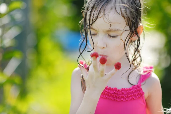 Ahududu yiyen sevimli küçük kız — Stok fotoğraf