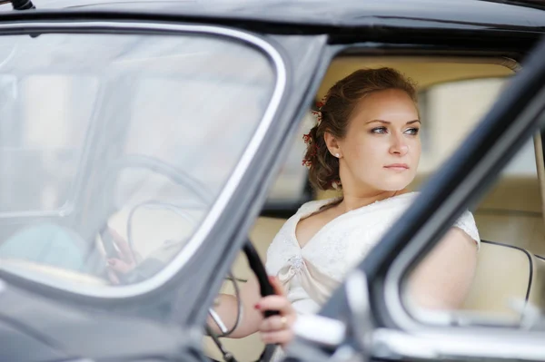 Beautiful young bride portrait in a car — Stock Photo, Image