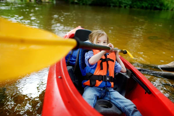 Niña feliz en un kayak en un río — Foto de Stock