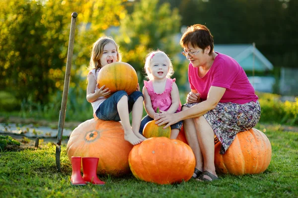 Two little sisters sitting on a huge pumpkins — Stock Photo, Image