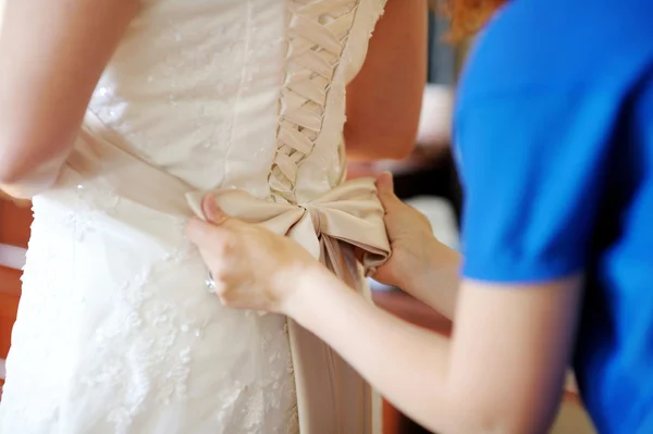 Ajudando a noiva a colocar seu vestido de noiva — Fotografia de Stock