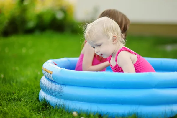 Twee kleine zusters van de broers en zussen plezier maken met water — Stockfoto