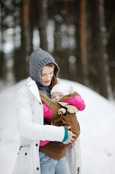 Jonge moeder en haar kleine baby in een drager — Stockfoto