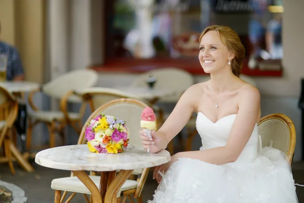 Young bride having an ice cream in outdoor cafe — Stock Photo, Image