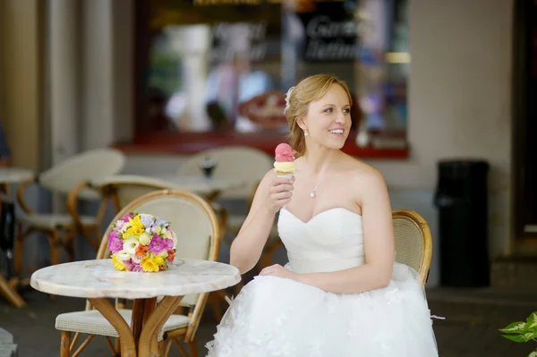 Young bride having an ice cream in outdoor cafe — Stock Photo, Image