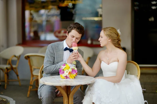 Bride and groom having an ice cream outdoors — Stock Photo, Image