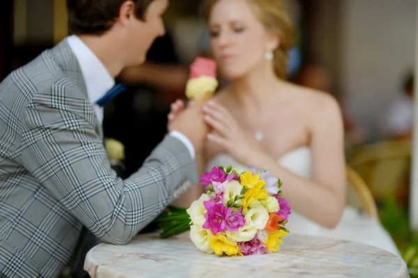 Bride and groom having an ice cream outdoors — Stock Photo, Image