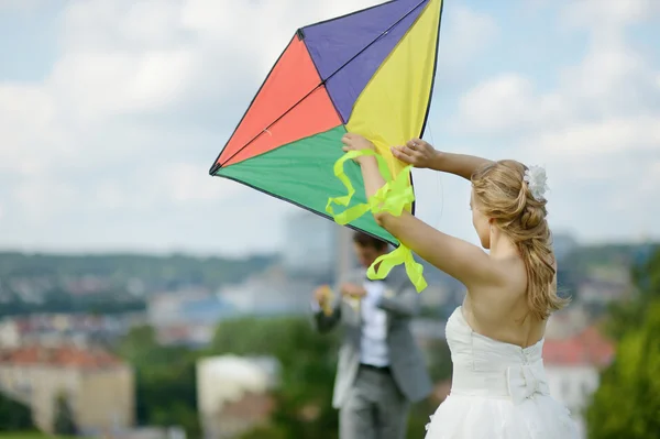 Sposa e sposo volare un aquilone il giorno del matrimonio — Foto Stock