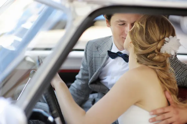 Noiva e noivo em um carro de casamento — Fotografia de Stock