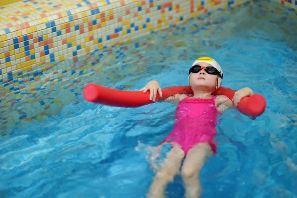 Klein meisje leren om te zwemmen met zwembad noodle — Stockfoto