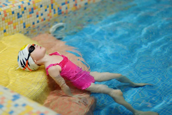 Little girl exercising while learning to swim — Stock Photo, Image