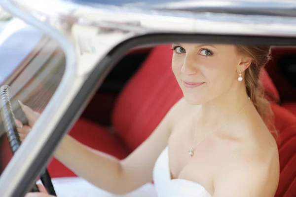 Beautiful young bride portrait in a wedding car — Stock Photo, Image