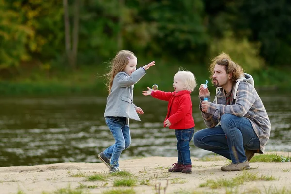 Junger Vater mit seinen beiden kleinen Töchtern — Stockfoto